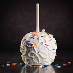 Birthday cake caramel apple topped with white chocolate drizzle and colorful sprinkles